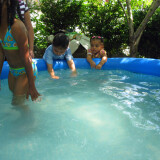 Children swim in an inflatable pool in Jorge Torres’ garden in the Bronx.